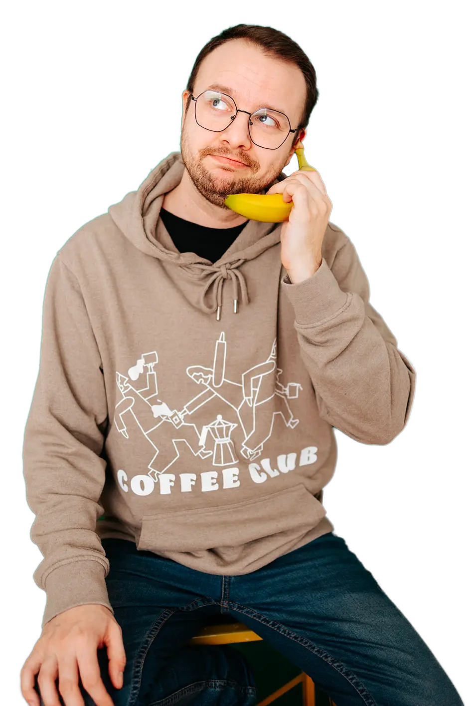 Photo de moi assis sur un tabouret, avec une banane dans la main comme si c'était mon téléphone.